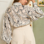 STYLEVAVA navy floral balloon sleeve blouse with tie-neck, model wearing size S