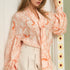 STYLEVAVA orange floral balloon sleeve blouse with tie-neck, model wearing size S
