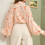 STYLEVAVA orange floral balloon sleeve blouse with tie-neck, model wearing size S